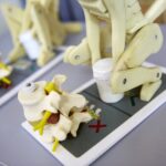 Anatomical model showing a human pelvis and spine on a display stand for educational purposes.